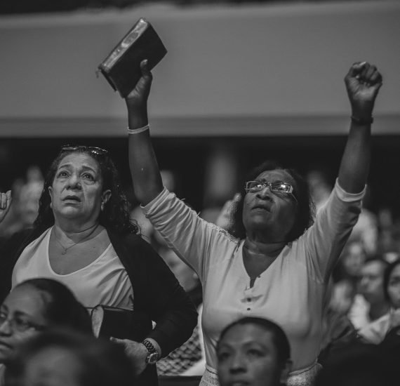 pexels-photo-2774570-2774570 A heartfelt moment of worship in a crowded indoor religious gathering.